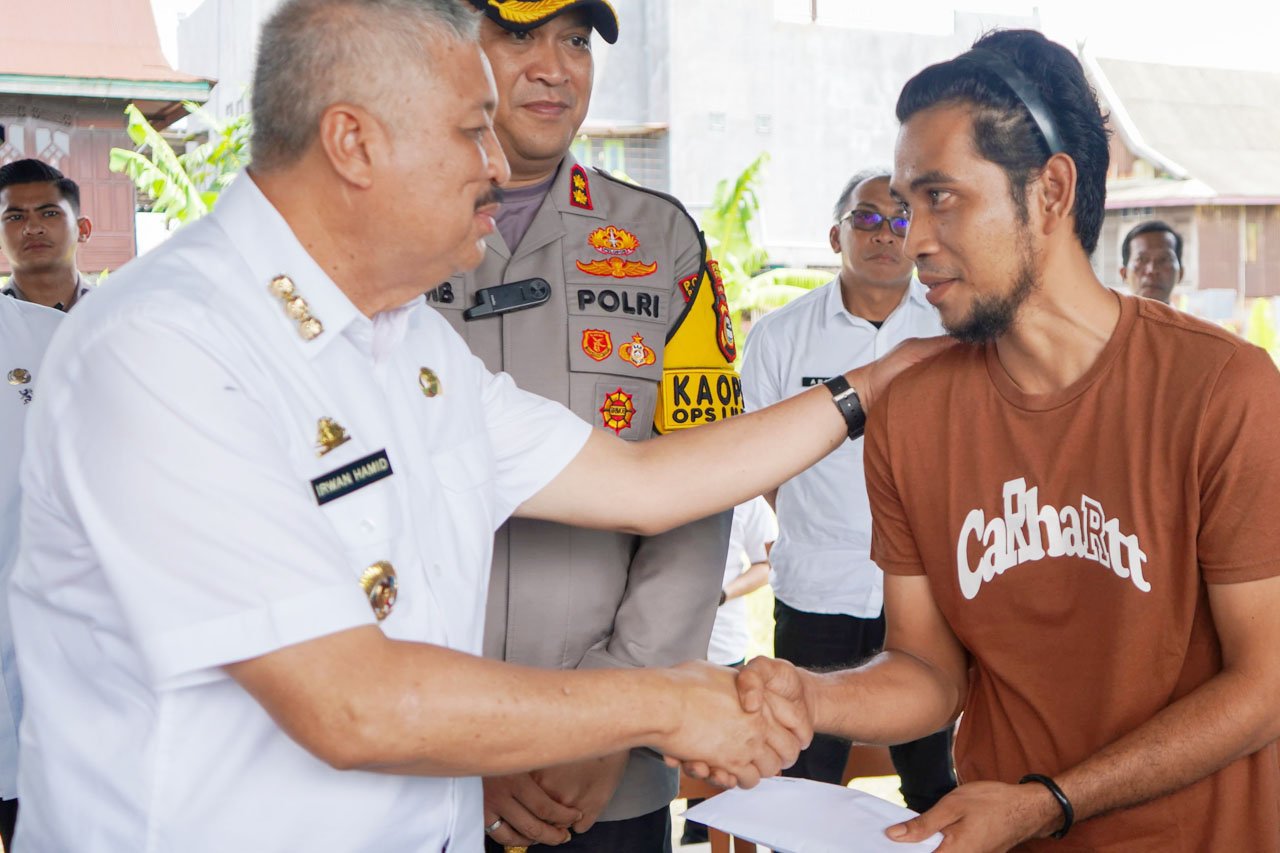 Bupati Pinrang H. A. Irwan Hamid menyerahkan bantuan tunai kepada warga korban angin kencang sebagai bentuk kepedulian pemerintah daerah.