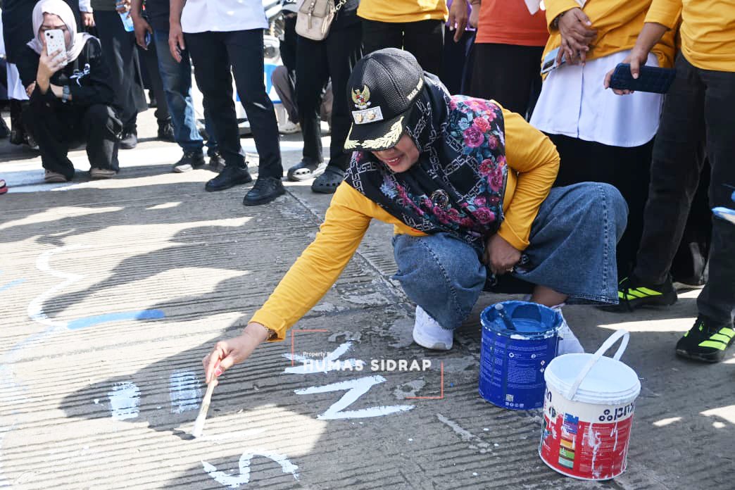 Wakil Bupati Sidrap Nurkanaah melukis kanvas jalan beton di Pasar Baru Rappang, Kecamatan Panca Rijang