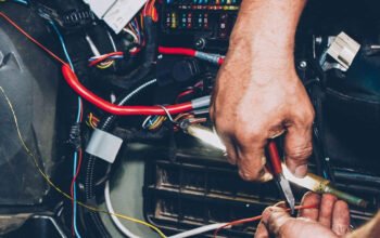 pemeriksaan kabel dan sistem kelistrikan mobil listrik oleh teknisi di ruang mesin