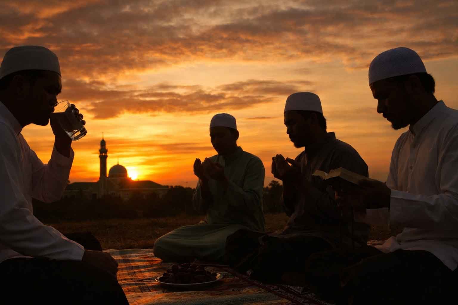 umat muslim berbuka puasa ramadan di sekitar masjid saat matahari terbenam