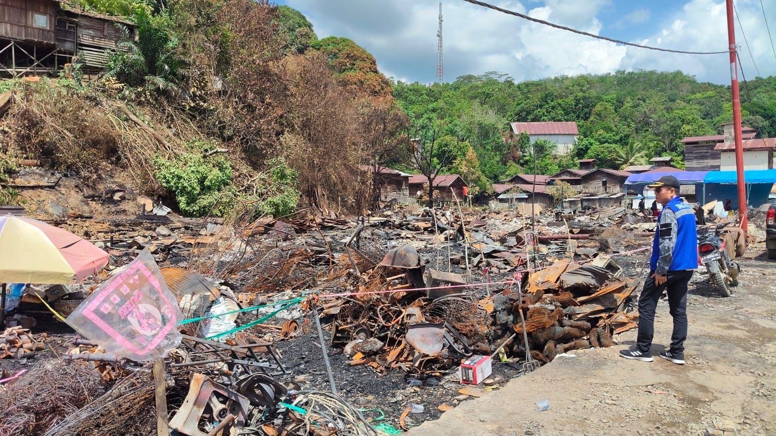 petugas meninjau lokasi kebakaran permukiman warga di desa batu timbau kutai timur