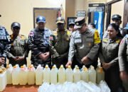 aparat menunjukkan barang bukti sopi hasil razia di pelabuhan pomako mimika