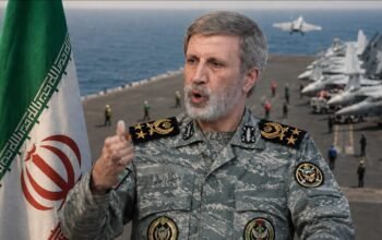 Ilustrasi Amir Hatami dan bendera Iran berlatar kapal induk terkait imbalan bagi penangkap tentara AS.