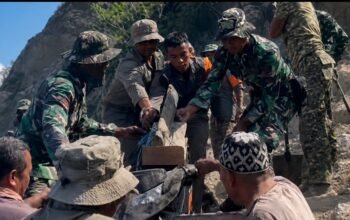 Prajurit TNI membantu warga menyalurkan bantuan logistik pascagempa di Flores, NTT