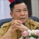 Plt Gubernur Riau SF Hariyanto mengenakan seragam dinas dengan latar bendera Indonesia.