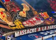 Suporter PSG membentangkan tifo bergambar gergaji mesin berdarah yang menghancurkan lambang Barcelona dalam pertandingan Liga Champions 2026