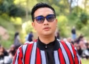 Bupati Klaten Hamenang Wajar Ismoyo mengenakan kacamata hitam dan jaket bergaris merah saat berada di luar ruangan.