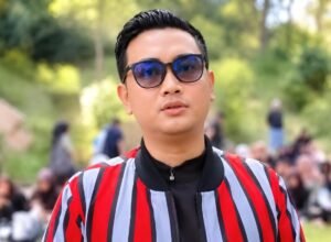 Bupati Klaten Hamenang Wajar Ismoyo mengenakan kacamata hitam dan jaket bergaris merah saat berada di luar ruangan.
