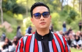 Bupati Klaten Hamenang Wajar Ismoyo mengenakan kacamata hitam dan jaket bergaris merah saat berada di luar ruangan.