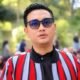 Bupati Klaten Hamenang Wajar Ismoyo mengenakan kacamata hitam dan jaket bergaris merah saat berada di luar ruangan.