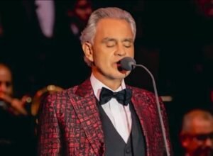 Penyanyi tenor berjas merah tampil di panggung, ilustrasi berita MUI menolak konser Andrea Bocelli di Indonesia.