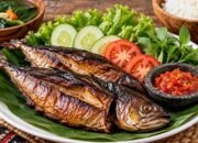 Ikan asap matang yang disajikan bersama sayuran sebagai ilustrasi cara aman mengonsumsi ikan asap.